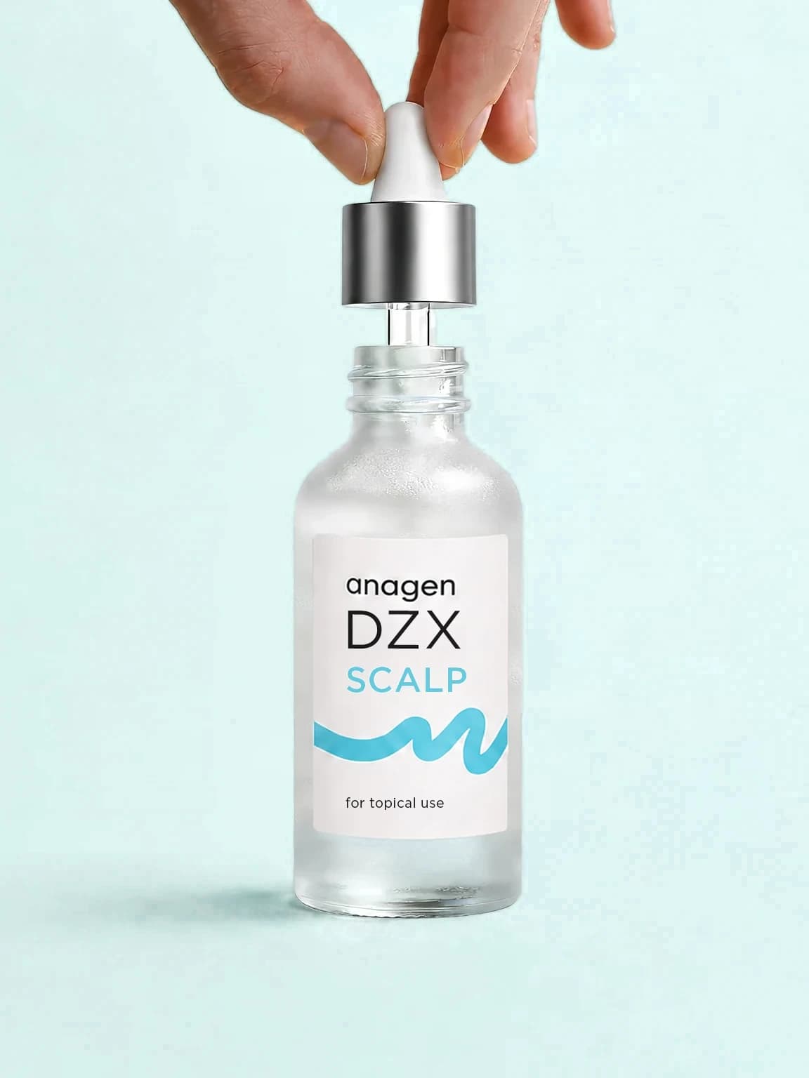 A hand lifting the dropper from a bottle of anagen DZX Scalp, the investigational topical diazoxide preparation